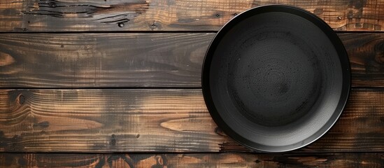 Aufkleber - Top view of a black plate on a kitchen table with space for text or image.