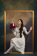 © master1305 - Wines loves, vintage fashion and modern humor. Elegant young woman in white dress sitting in picture frame with giant wine glass on retro background. Concept of history, comparison of eras, remake