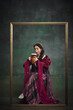 © master1305 - Portrait of beautiful medieval queen royal person in luxurious period attire sipping lager foamy beer against vintage green background. Oktoberfest traditions. Concept of history, comparison of eras