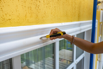 Wall Mural - A person is painting a wall with a yellow trim