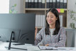 © Tj - Sharing good business news. Attractive young businesswoman talking on the mobile phone and smiling while sitting at her working place in office and looking at laptop PC.