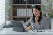 © Tj - Sharing good business news. Attractive young businesswoman talking on the mobile phone and smiling while sitting at her working place in office and looking at laptop PC.