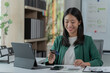 © Tj - mage of a young Asian businesswoman holding a credit card.