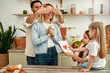 © Valerii Apetroaiei - Family Surprises Mom With Card in Kitchen