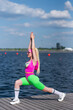 © Granmedia - Young beautiful blonde woman in sports shorts, a pink bodysuit and pink sunglasses is doing sports outdoors. Doing exercises in sportswear. Sports, Active lifestyle, sports training, healthy lifestyle