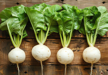 Wall Mural - A photo of four white turnips with green leaves on top, arranged neatly and cut in half on the wooden table, captured from above at an angle.