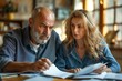 © ArtCraft - Mature couple going over legal documents. This image can be used to portray themes of divorce, financial planning, or seeking advice from a divorce lawyer. Suitable for legal and advisory content.