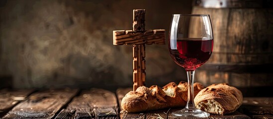 Wooden cross, red wine with bread on an aged wooden table elegantly staged as a copy space image.