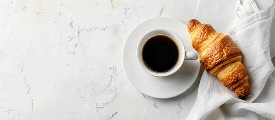 Leinwandbilder - Croissant beside black coffee on a white table with copy space image.