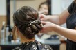 © Ilia K - Hairdresser-stylist styles women's hair with pigtails and barrettes with rhinestones