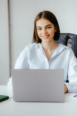 Poster - Young Professional Woman Working on Laptop at Office Desk