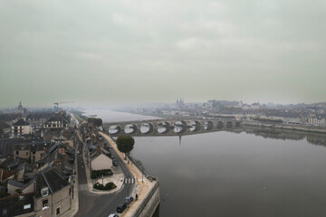 Wall Mural - A misty morning view of the arched bridge in saumur