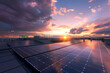 © mila103 - A solar panel array is shown in the evening sky, with the sun setting behind it
