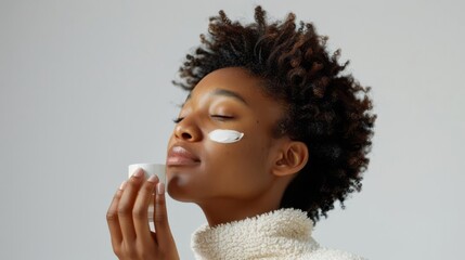 Woman applying night cream, white background, nighttime skincare routine