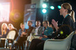 © smth.design - Businesswoman Speaking at a Conference Panel Discussion with Attentive Audience and Stage Lights