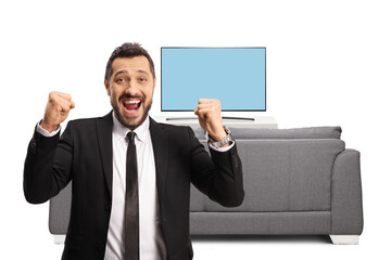 Sticker - Young businessman gesturing happiness in front of tv and looking at camera