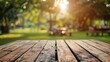 © Larysa - Empty wooden table and blurred view of friends cooking food on barbecue grill in park