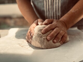 Wall Mural - Woman baker kneading the dough.
