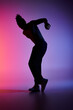 © LIGHTFIELD STUDIOS - A young African American man dances in silhouette against a vibrant gradient background.