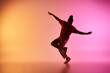 © LIGHTFIELD STUDIOS - A young African American male dancer executes a move in a vibrant studio setting with a colorful gradient background.