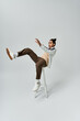 © LIGHTFIELD STUDIOS - A young African American man wearing a stylish outfit poses on a stool against a grey background.