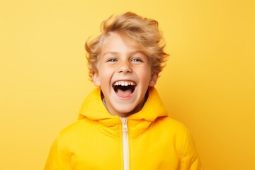 Poster - Surprised little boy in yellow hoodie over yellow background.