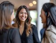 © Cetin - photo shows two women and one man in their late thirties smiling and talking to each other at an office event