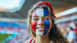 © FATNA - Happy French woman supporter with face painted in French flag colors, blue white and red, fan at a sports event such as football or rugby match, blurry stadium background and copy space