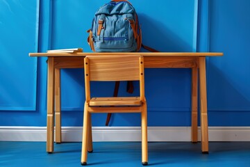 Poster - a backpack sitting on a wooden desk next to a chair