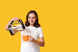 © Pixel-Shot - Beautiful young woman pouring hot water from modern electric kettle into mug on yellow background