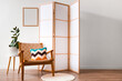 © Pixel-Shot - Interior of living room with wooden folding screen, armchair and blank frame