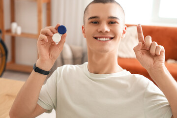 Wall Mural - Young man with contact lenses at home, closeup