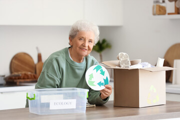 Sticker - Senior woman with recycle sign sorting trash in kitchen