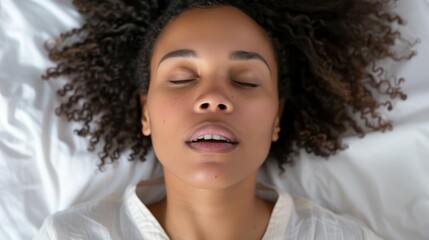 Wall Mural - A woman with curly hair is sleeping on a bed