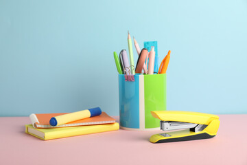 Wall Mural - Yellow stapler and other stationery on color background