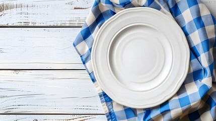 Wall Mural - Empty white plate on wooden white table with checkered blue linen napkin. Flat lay, top view, copy space