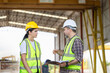 © JU.STOCKER - Engineer and foreman worker checking project at building site, Engineer and builders in hardhats discussing on construction site, Teamwork concepts