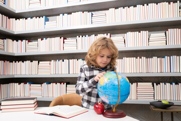 Fototapete - School and students in classroom. Education kids. Clever Child pupil student in the school class. Studying and learning concept. School boy in library near school supplies. Kid learn geography with