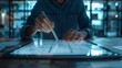 © Tackey - Close-up of a person using a stylus on a digital tablet, creating a design in a modern workspace with blue lighting.
