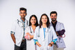 © StockImageFactory - Group portrait of four indian asian young doctors in uniform standing against white background