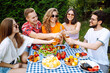 © maxbelchenko - Group of friends having backyard dinner party together. Young people enjoying leisure time together outside toasting with beer and barbecue. Vacation, picnic, weekend, nature.