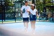 © Drazen - Happy couple of athletes talking while playing mixed doubles in paddle tennis.