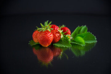 Wall Mural - red ripe strawberry spring on a black background