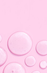 Wall Mural - round drops of transparent gel serum on pink background