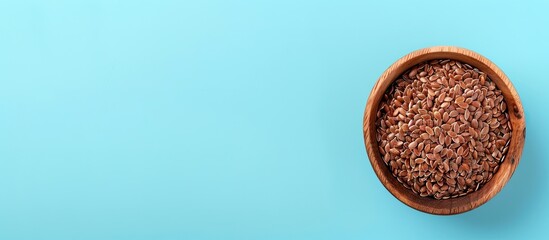 Leinwandbilder - Brown flax seeds in wooden bowl Isolated on pastel background. with copy space image. Place for adding text or design