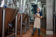 © sirisakboakaew - Asian man works at a craft beer factory as a brewer operating the brewery machinery. Craft beer production is a small business.