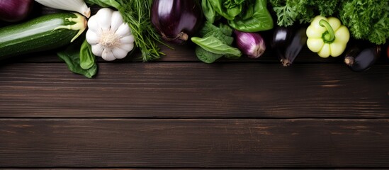 Aufkleber - Top view of various fresh seasonal vegetables like cucumbers, white eggplants, fennel, basil, and kale leaves on a wooden table with copy space image.