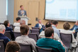 © Anton Gvozdikov - Group of business professionals attending a tech conference, listening to a presentation. Engaged audience seated in a modern conference room.