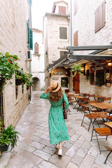 Canvas Print - Beautiful woman wearing summer dress walking in historic city street. Fashion, style, tourism concept.