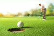 © Paitoon - Golfer putting golf ball to the hole on green golf.
